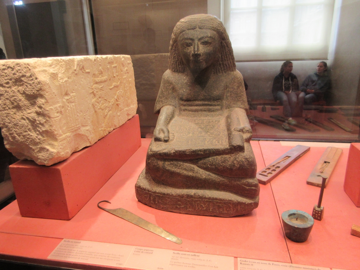 A second sculpture of a scribe working with scribal tools.